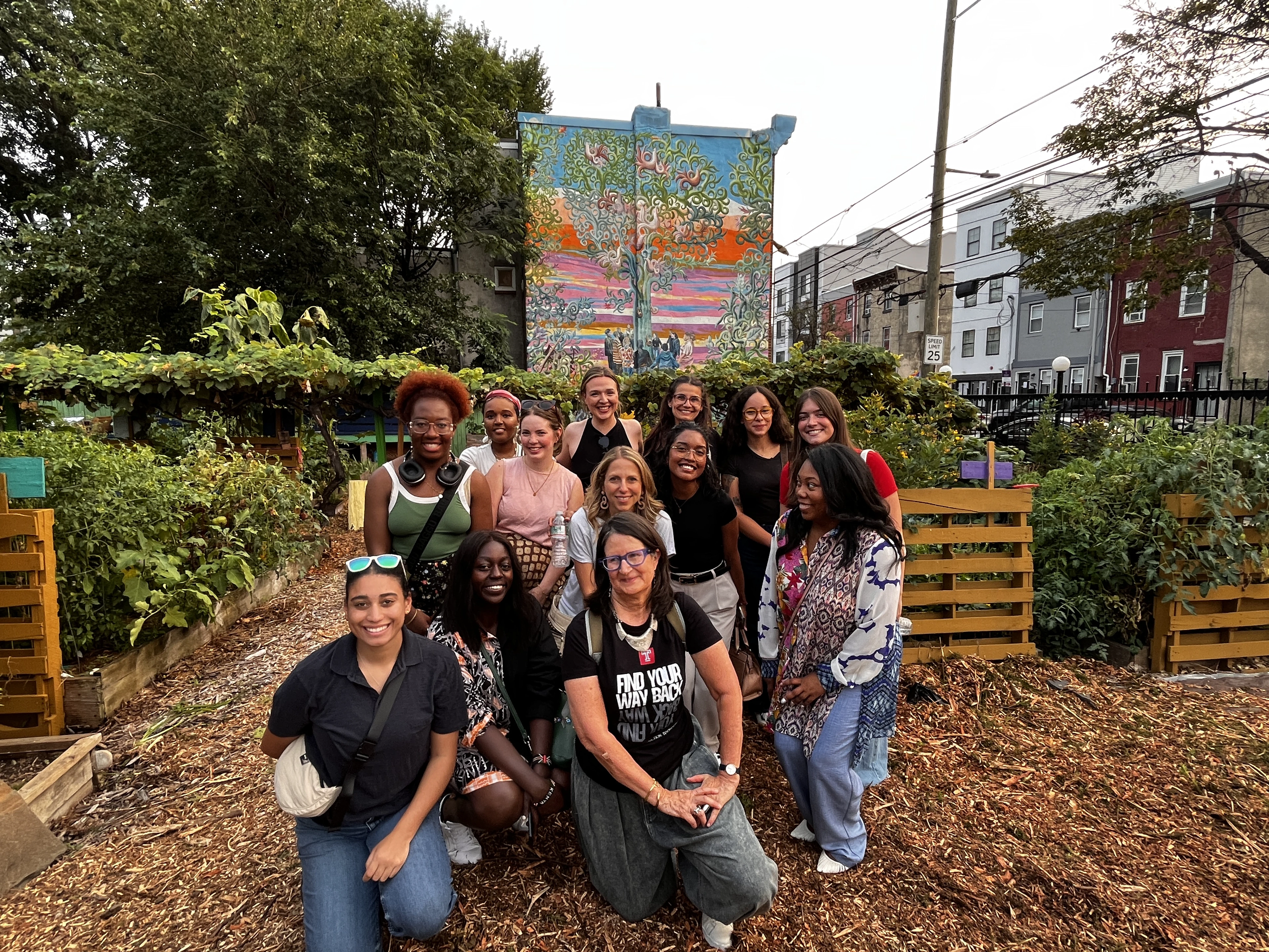 A group photo of women in a garden space.