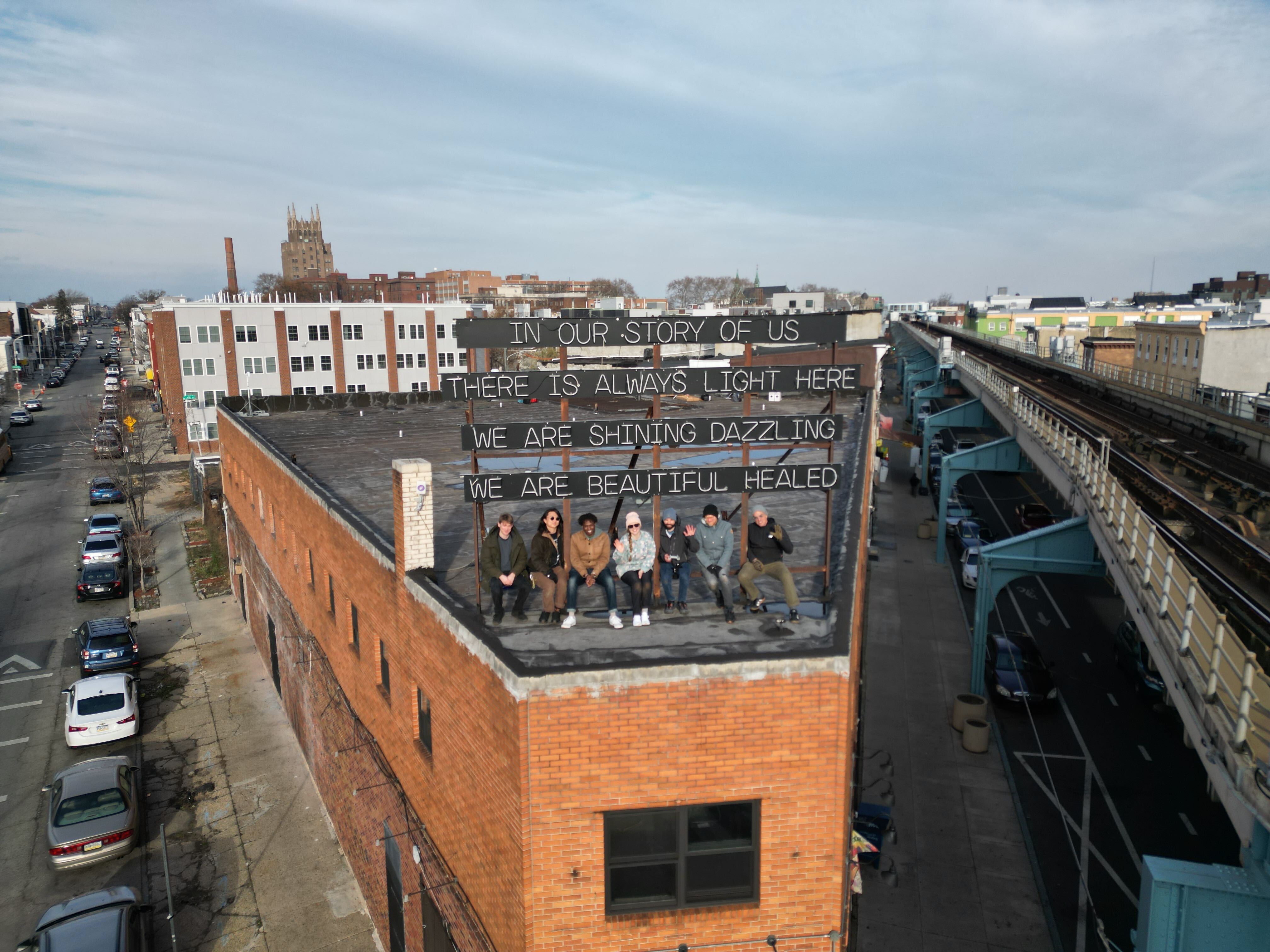 A wide panorama photo with 4 PCW volunteers on a roof.